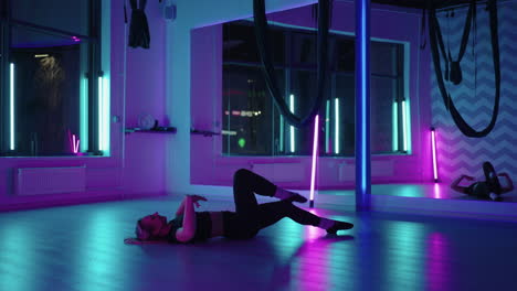 Eine-Frau-Tanzt-In-Einem-Studio-Mit-Neonlicht-Und-Führt-Anmutige-Übungen-Und-Bewegungen-Aus-Dehnübungen-Und-Tanzen-In-Zeitlupe-Aus